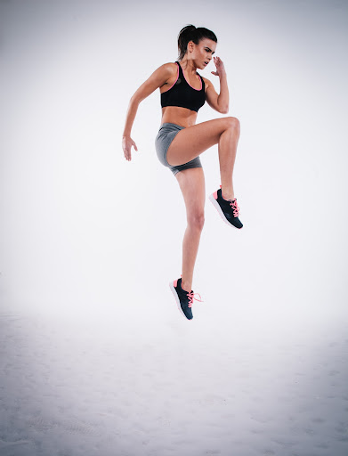 Sportliche Frau springt in die Luft